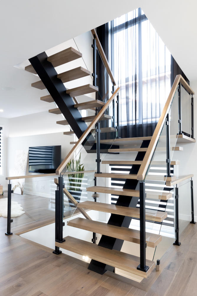 New York stairs in a turn and landing design with post and glass railing for a seamless appearance.