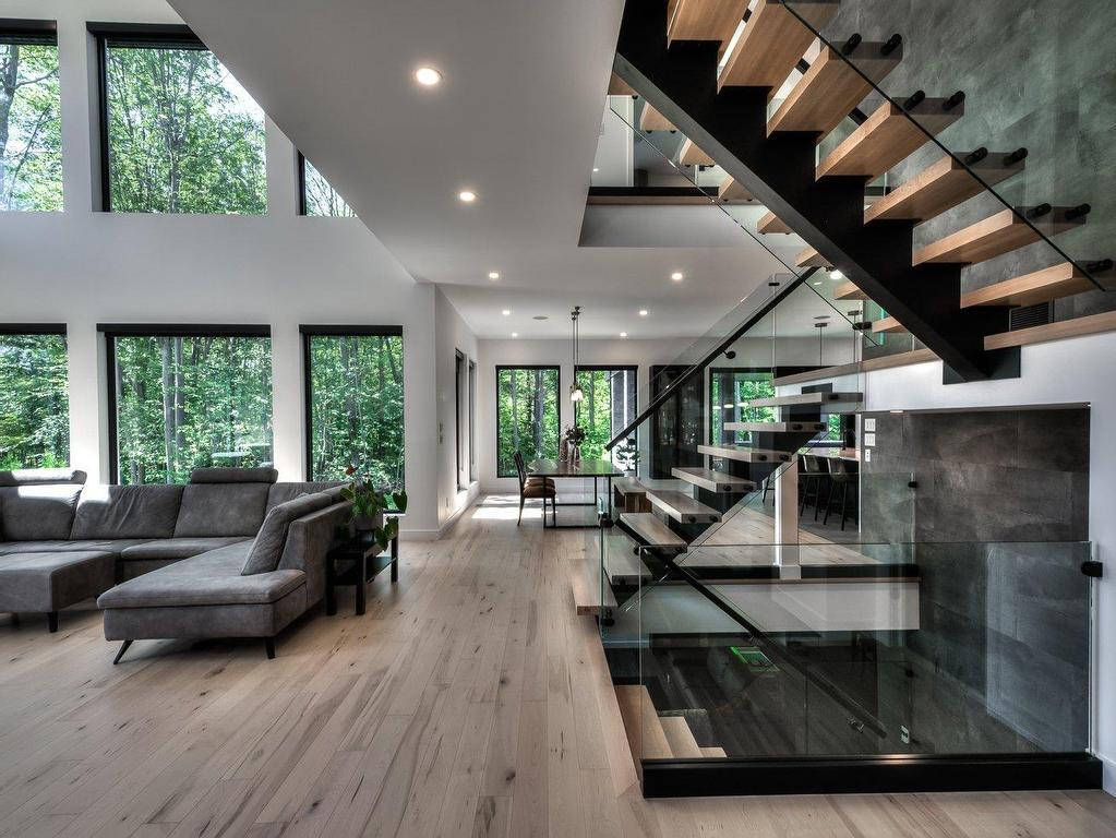 Paris stairs in a turn and landing design with black metal rails and standoff glass.